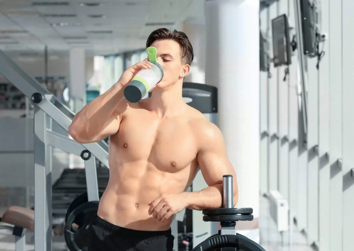 osoba pije szejka białkowego, siłownia, zdrowie