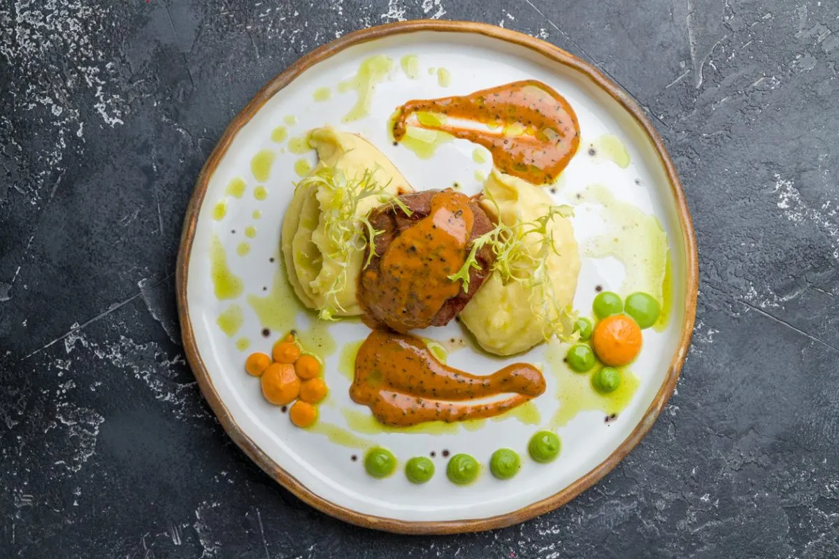 Mięso duszone z puree ziemniaczanym i pomarańczowym sosem. Idealny przepis na to, jak zrobić dobry sos do mięsa duszonego.