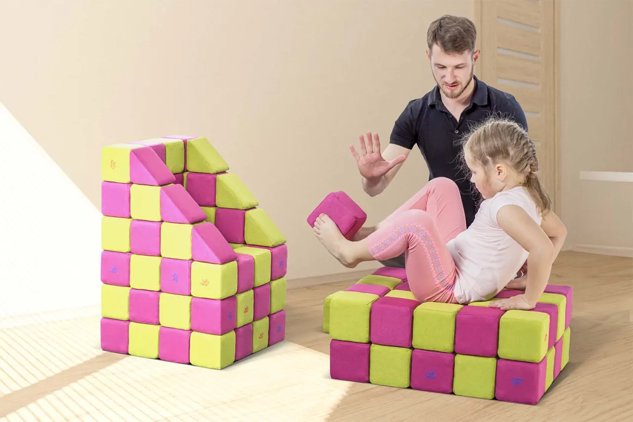 dziecko bawi się klockami z psychologiem, terapia przez zabawę, psycholog dziecięcy i zabawki