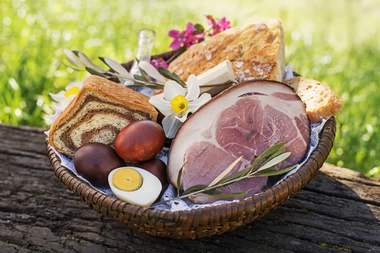 Koszyk wielkanocny z szynką, jajkami i chlebem. Czy w Wielką Sobotę można jeść mięso? Tradycja mówi, że nie, ale to zależy od regionu.