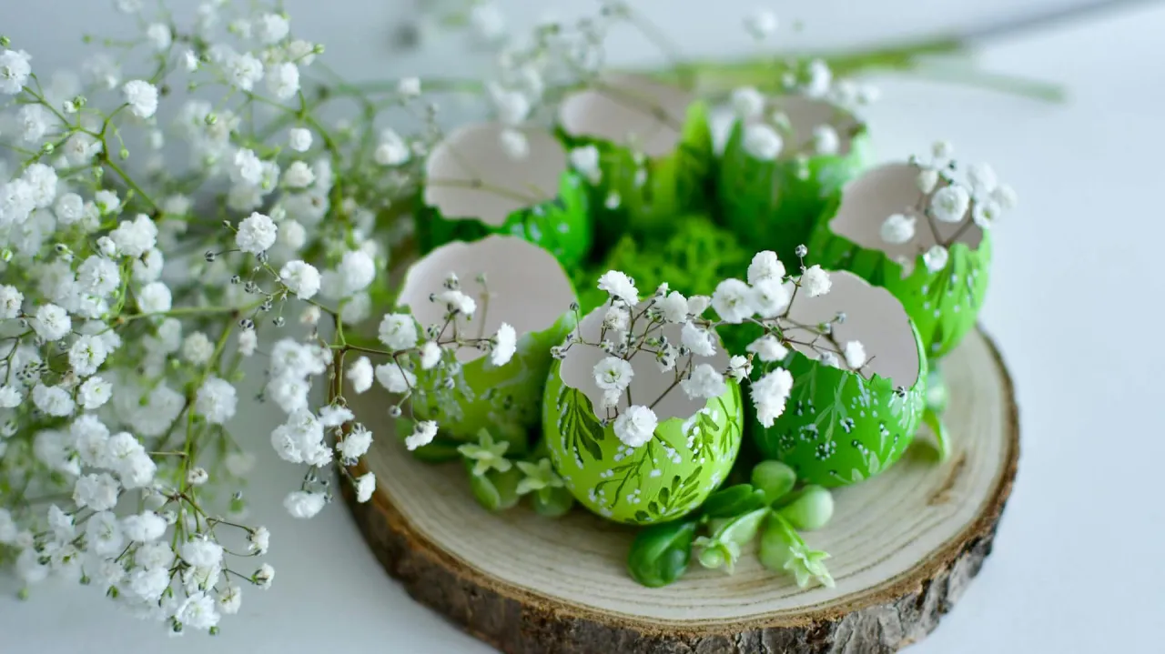 Nowoczesne, ręcznie robione stroiki wielkanocne z zielonych, zdobionych skorupek jajek i gipsówki na drewnianym plastrze.
