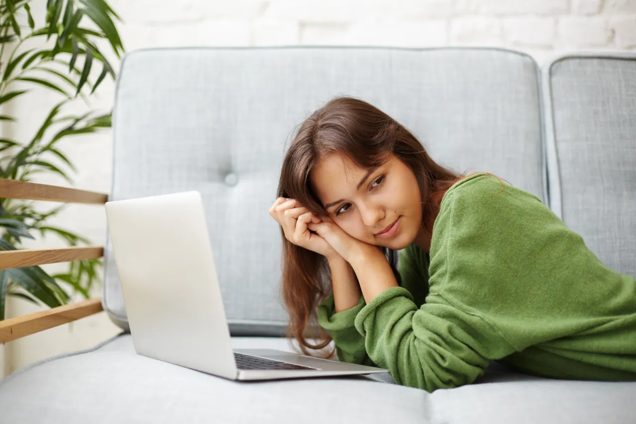 uczeń z laptopem uśmiechnięty w domu