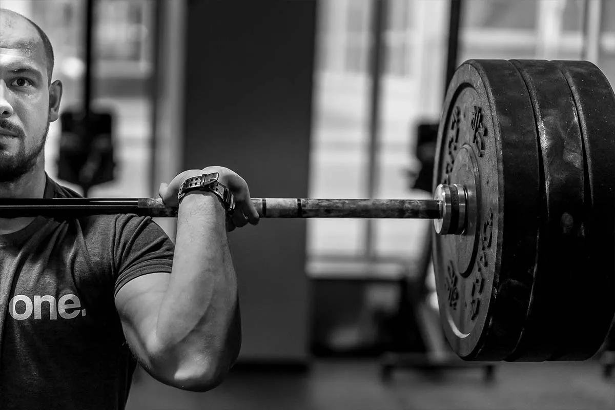osoba trenująca crossfit z ciężarami