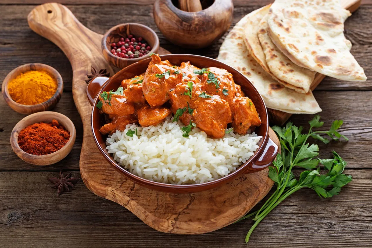 Kurczak Tikka Masala na talerzu z ryżem i naan