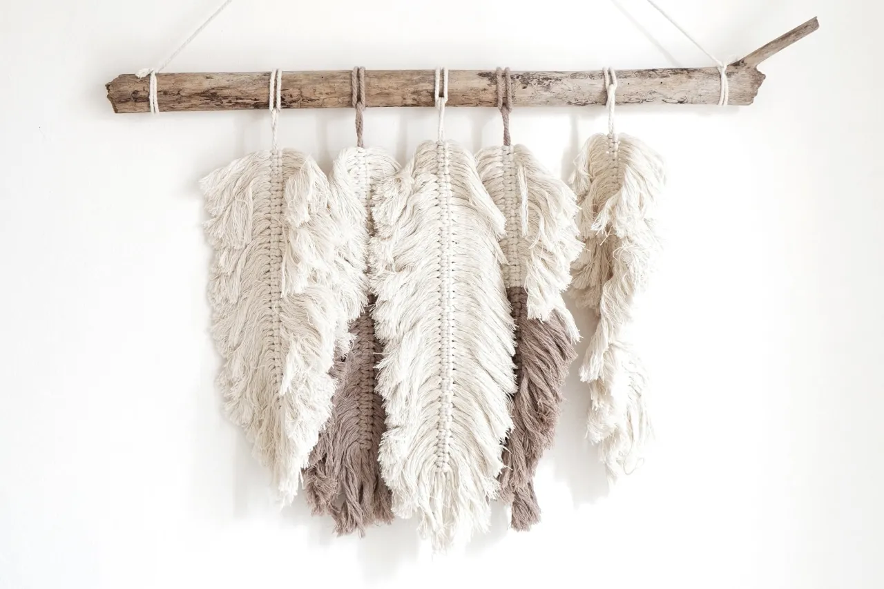 Makrama w kształcie pi&oacute;r, zawieszona na dryfującym drewnie. Dowiedz się, jak zrobić takie liście makrama.