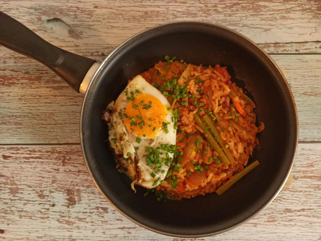 Ryż z warzywami i jajkiem sadzonym na patelni. To danie z dodatkiem kimchi, kt&oacute;re nadaje mu pikantny smak.