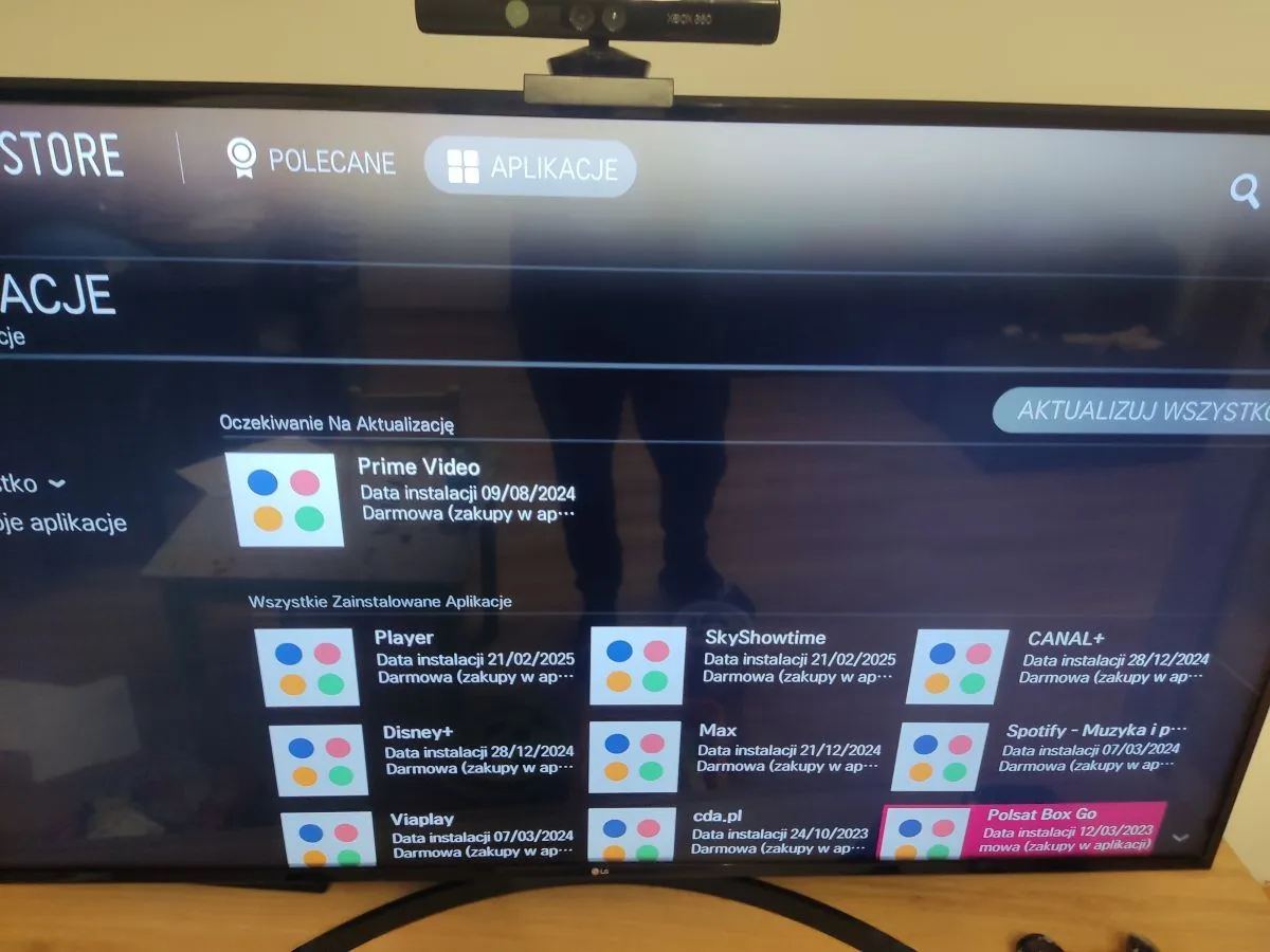 Ekran telewizora z listą zainstalowanych aplikacji, pokazujący jak zainstalować aplikacje na telewizorze. Widoczne m.in. Prime Video, Player, Disney+.