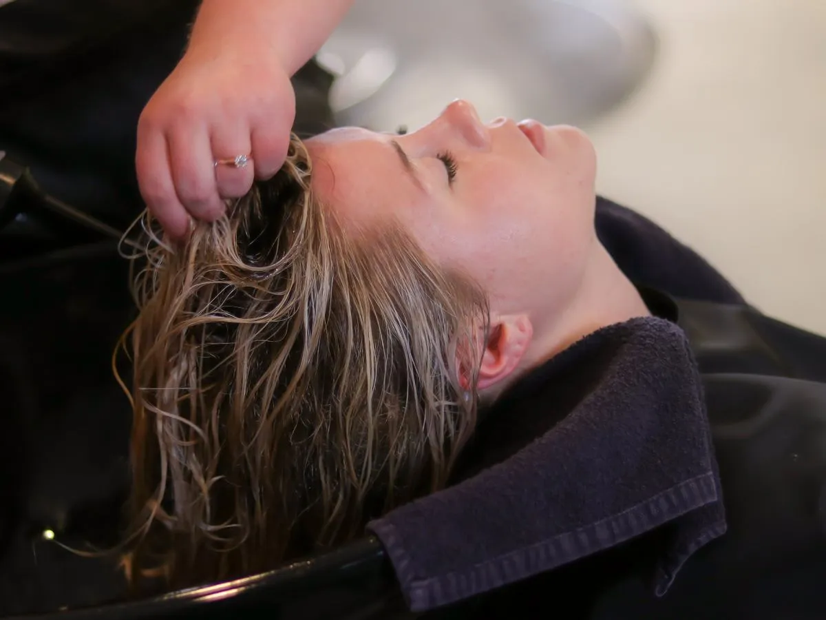 kobieta nakładająca maskę na włosy w domu, produkty do domowego botoksu