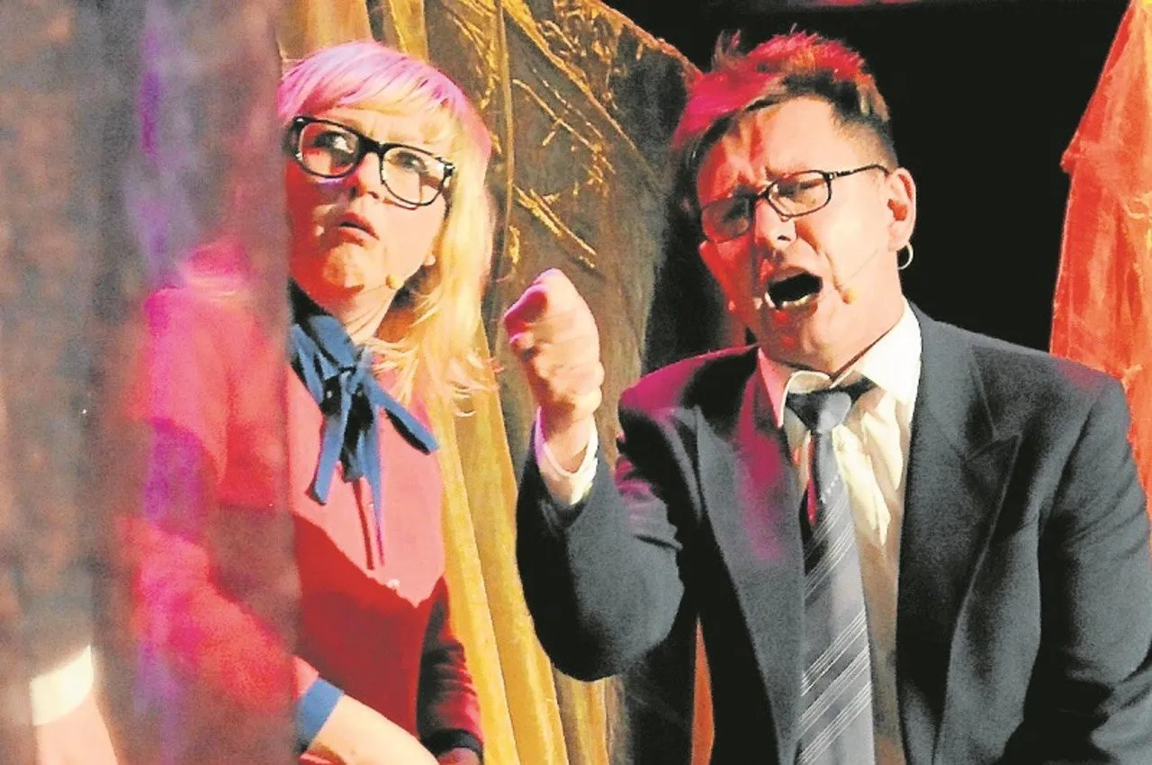 Aktorzy na scenie, przygotowujący kabaret na zakończenie roku szkolnego scenariusz. Kobieta w okularach i mężczyzna w garniturze z zaciętą miną.