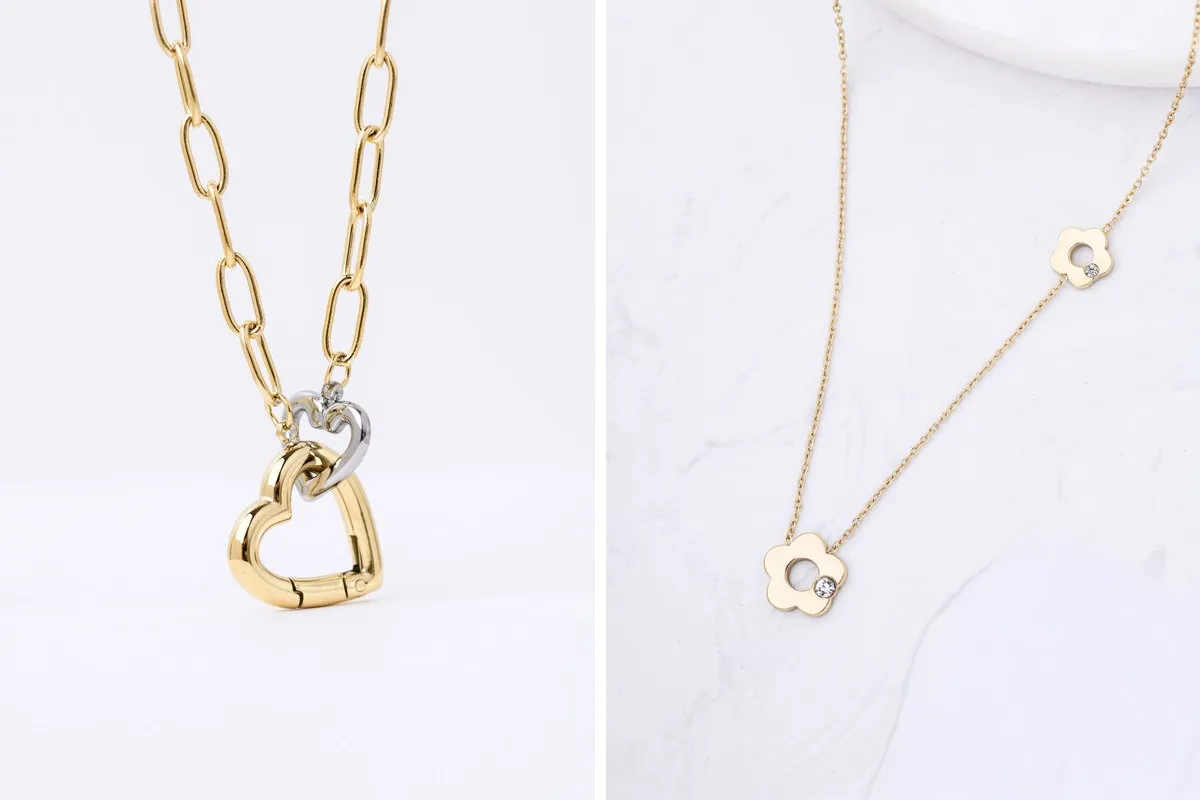 Dwa naszyjniki: jeden ze złotym sercem i łańcuszkiem z ogniw, drugi z kwiatkami i cyrkoniami. Oba wykonane ze stali chirurgicznej.