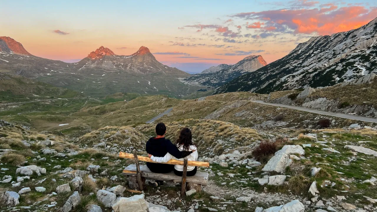 Para wpatrzona w zachód słońca nad górami Czarnogóry. Wjazd na malowniczą trasę widokową.