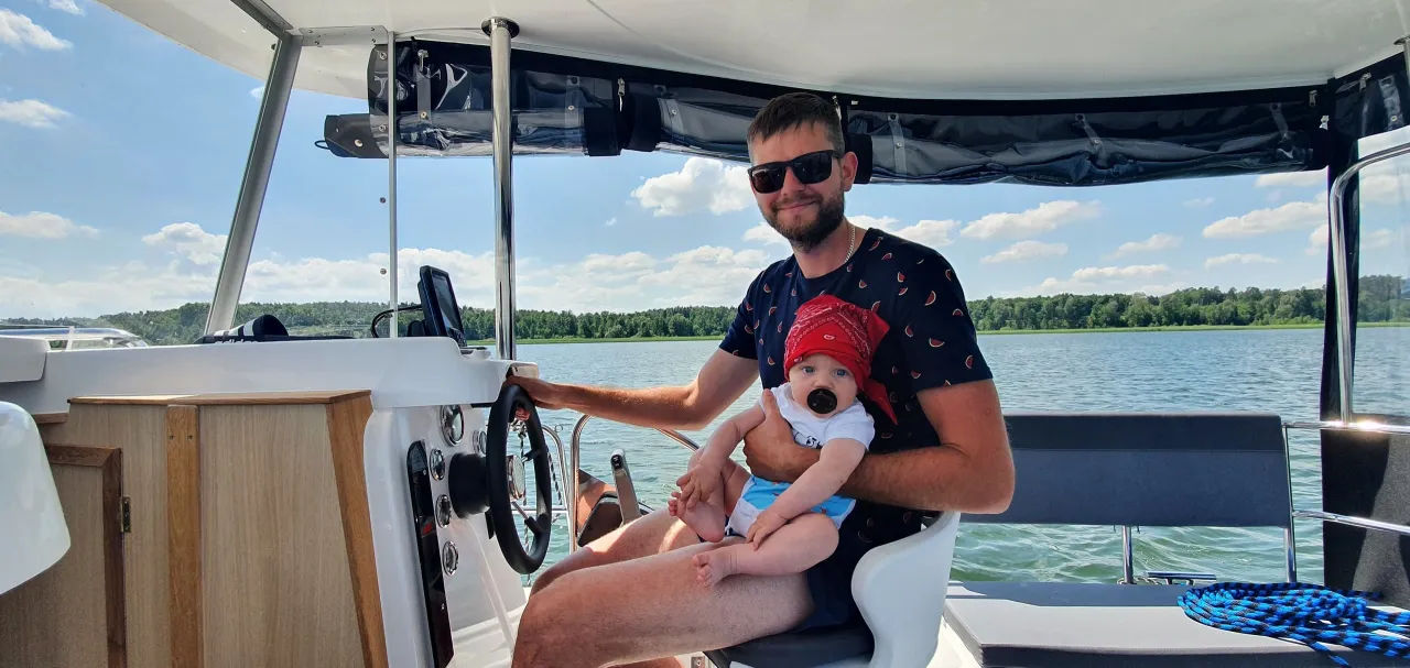 Rodzina z dziećmi na Mazurach, jezioro, łódka, słońce