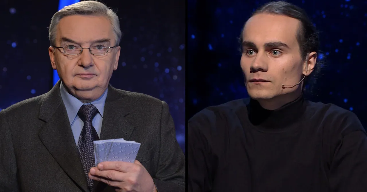 Starszy mężczyzna w okularach trzyma karty z napisem 