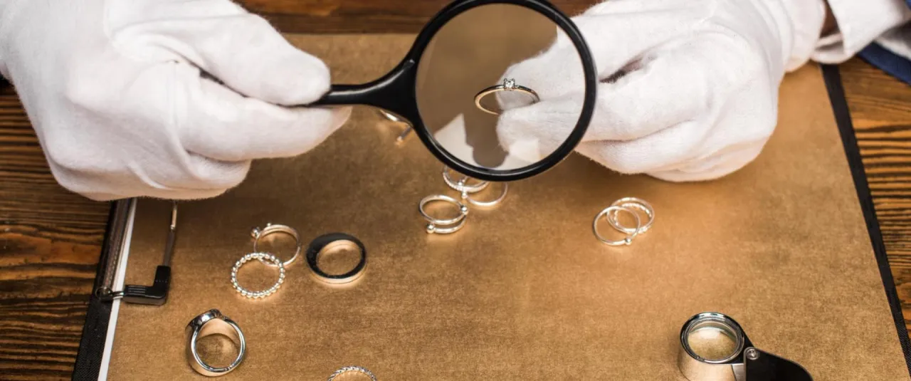 złota biżuteria i lupa