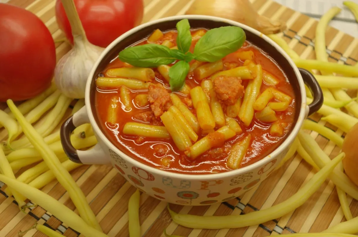 Pyszne danie z fasolki szparagowej w sosie pomidorowym z kawałkami kiełbasy. Idealne, co zrobić z ugotowanej fasolki szparagowej.