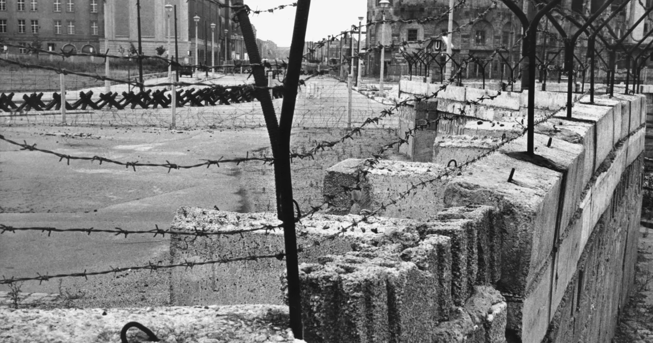 Kto wybudował mur berliński? Betonowe bloki i drut kolczasty świadczą o jego budowie.