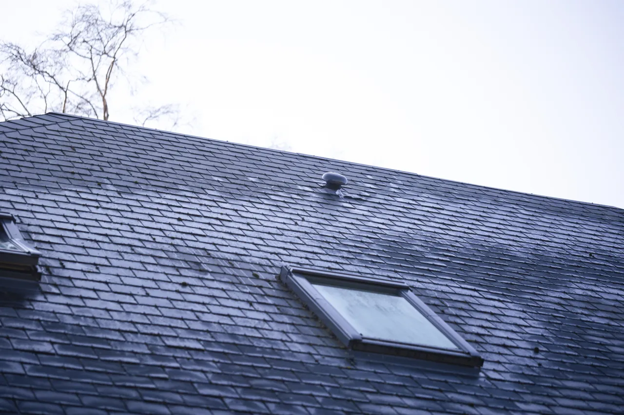 Dachówka płaska na mijankę pokrywa dach z oknem połaciowym.