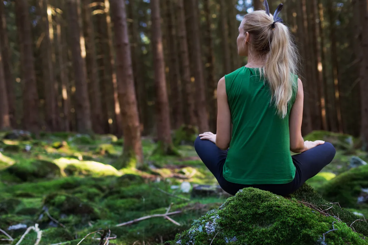 Osoba medytująca w otoczeniu natury, z dala od ekranów