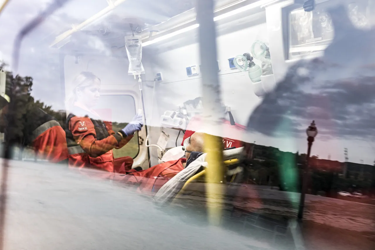 Ratownik medyczny w karetce w Norwegii przygotowuje kropl&oacute;wkę. Ubezpieczenie Norwegia zapewnia pomoc w takich sytuacjach.