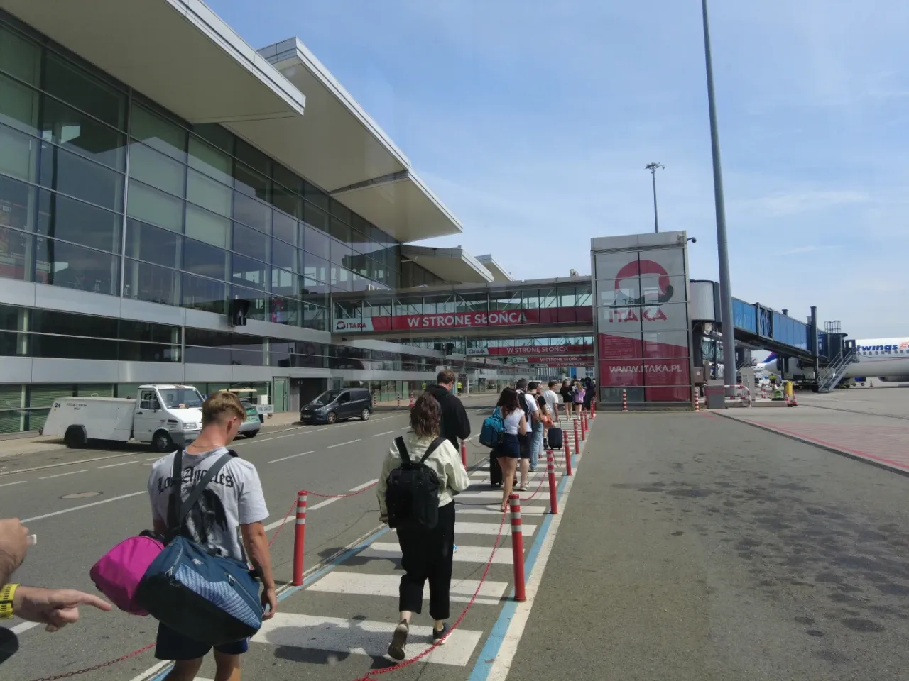 Ludzie idą do samolotu. Zastanawiasz się, czy można opuścić lotnisko podczas przesiadki?
