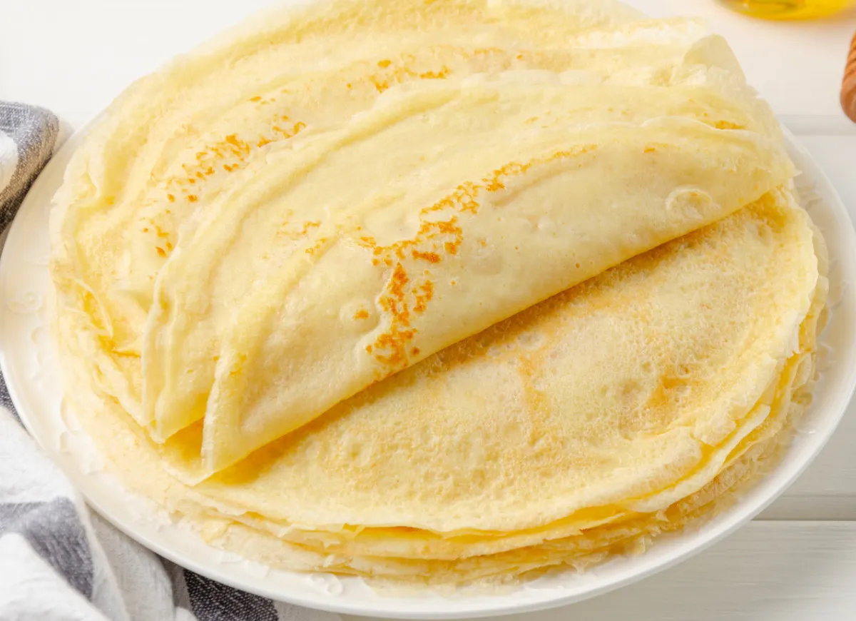 Stos cienkich naleśników, idealny obiad dla dziecka zamiast jajek. Delikatne, lekko zarumienione ciasto.