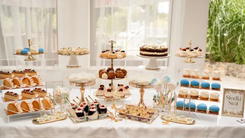 Słodki st&oacute;ł na komunię z r&oacute;żnymi ciastami i deserami