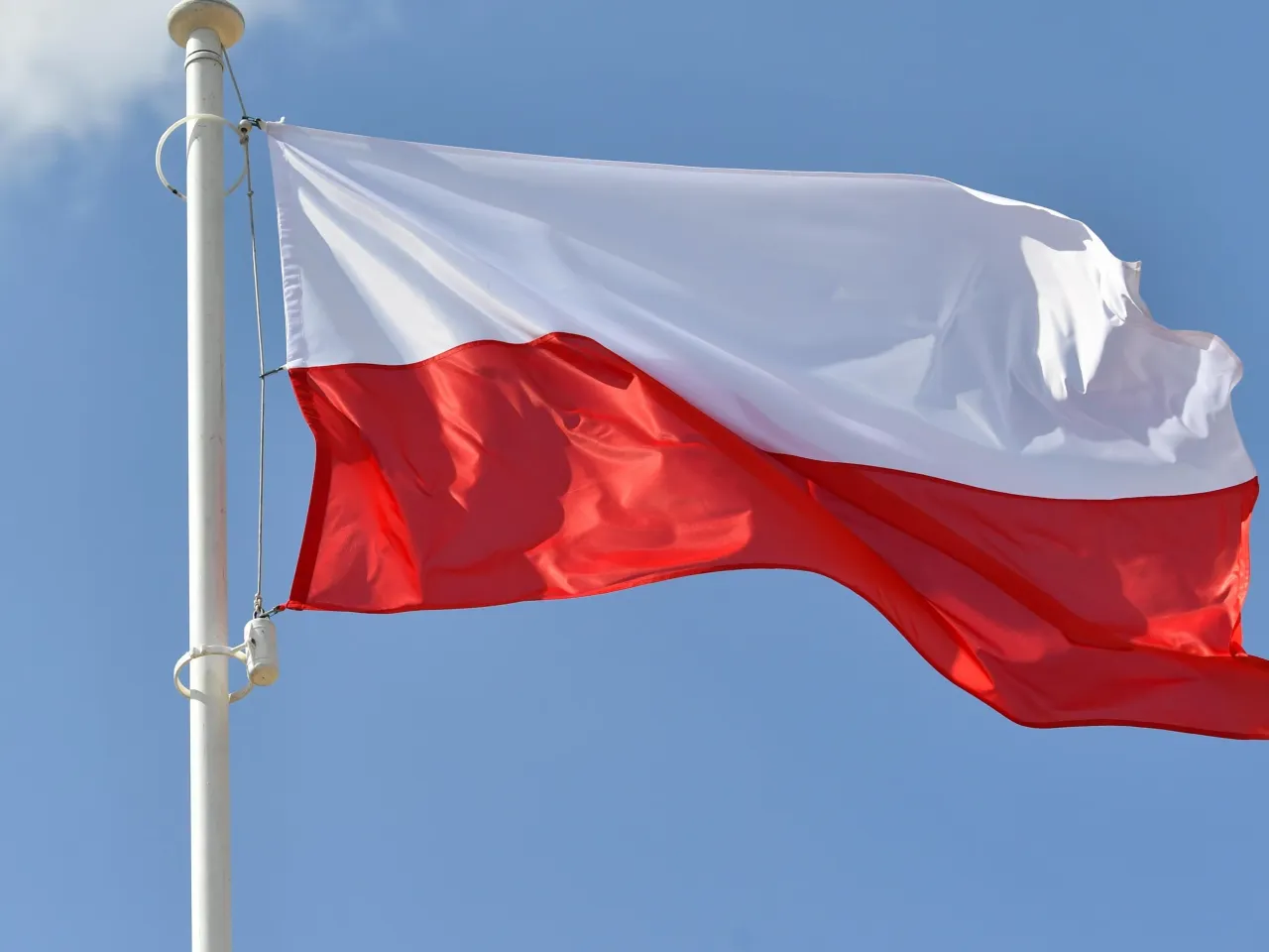 Różnica między Poland a Polish zobrazowana flagą i książką do języka polskiego