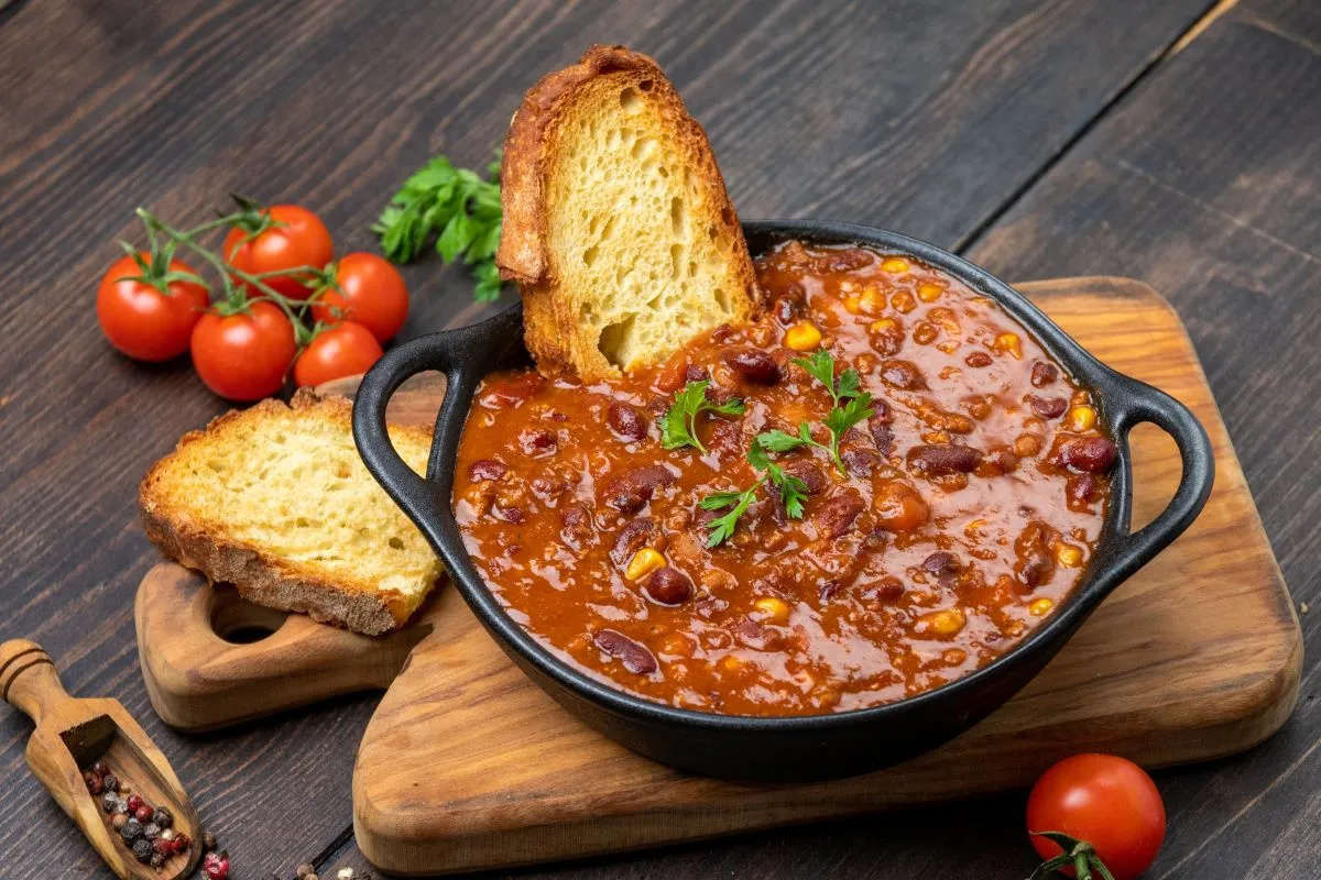 Pyszne chili con carne z fasolą i kukurydzą, podane z grzankami. Idealny przepis na zdrowy obiad, kt&oacute;ry rozgrzeje i nasyci.