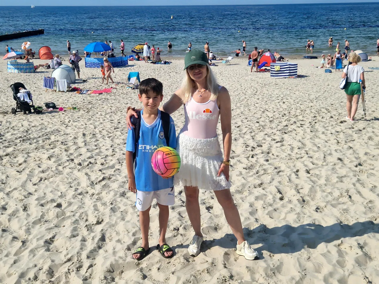 Rodzina z dzieckiem na czystej, strzeżonej plaży z Błękitną Flagą