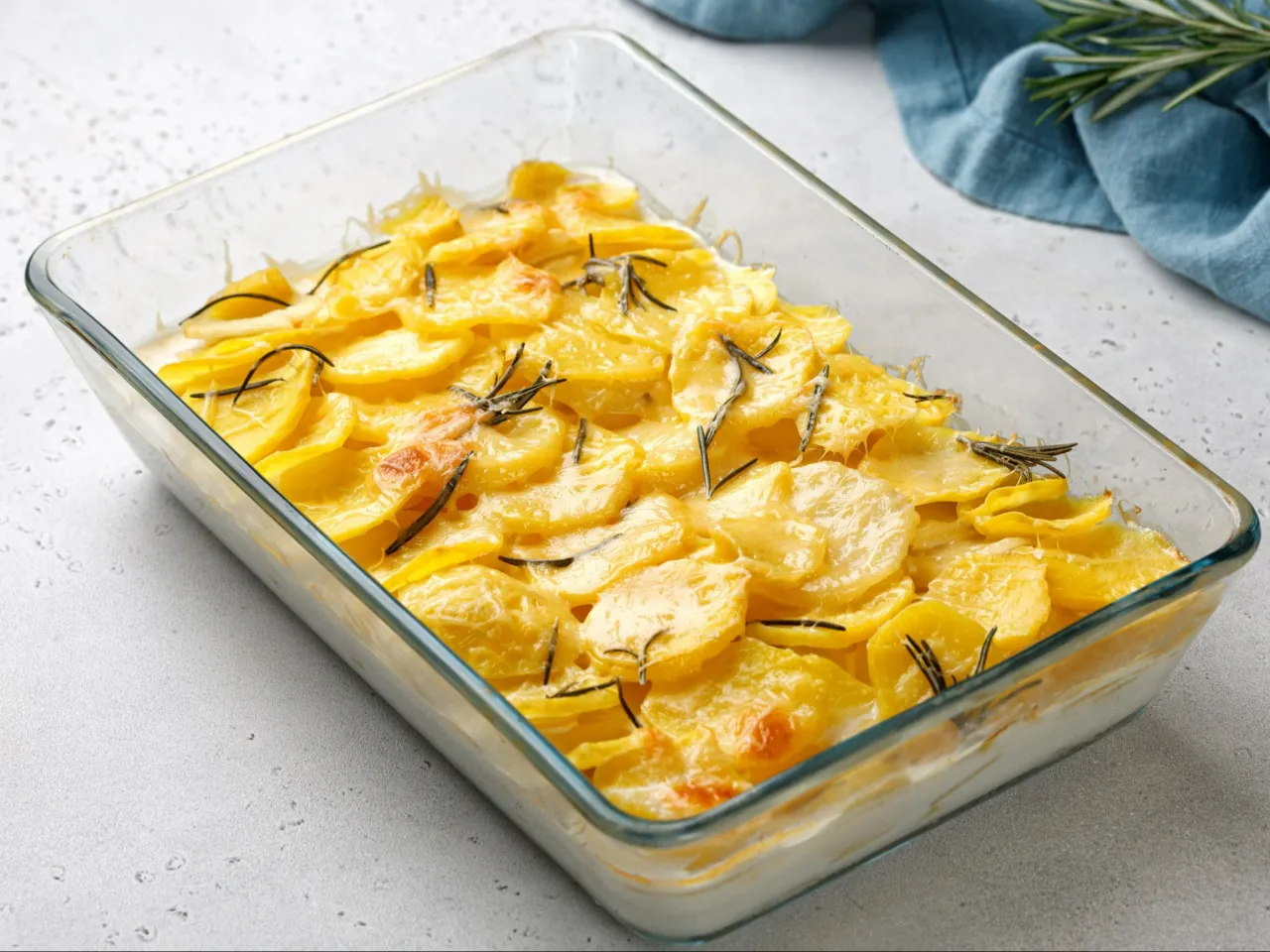 Zapiekane ziemniaki z serem i rozmarynem &ndash; pyszny pomysł, co można zrobić z ziemniak&oacute;w na obiad.