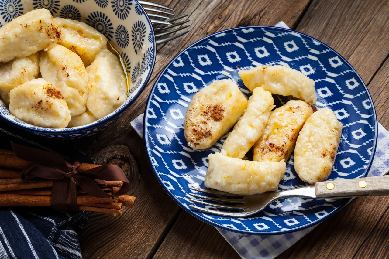 Pyszne leniwe pierogi na talerzu i w misce, posypane cynamonem. Idealne na śniadanie, gdy post scisly co mozna jesc.