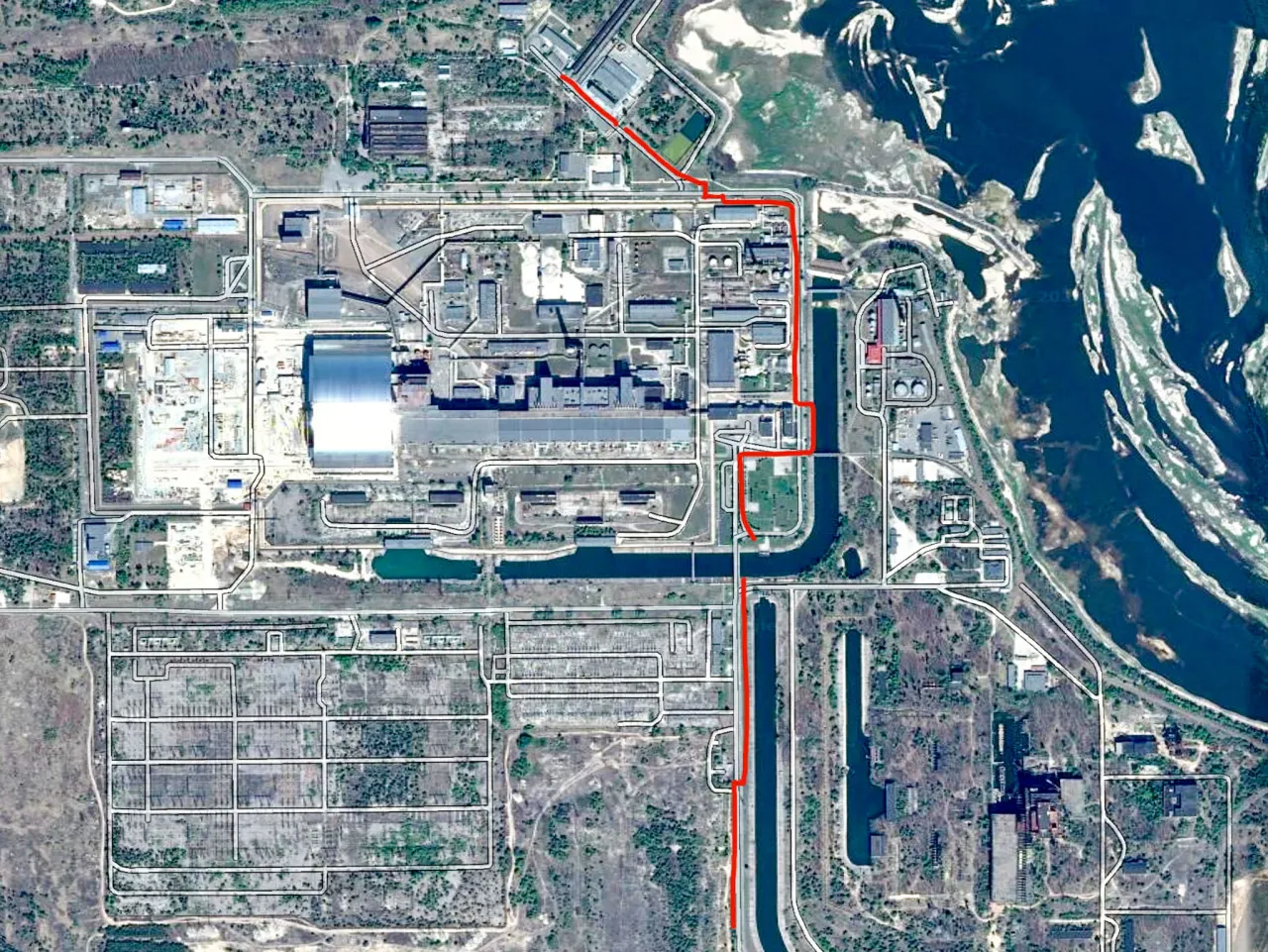 Widok satelitarny elektrowni w Czarnobylu, pokazujący jej rozległy teren z budynkami, drogami i zbiornikami wodnymi. Tu właśnie leży Czarnobyl.