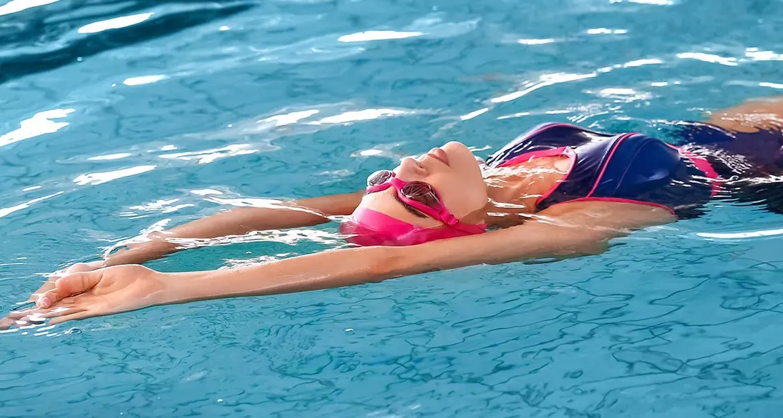 Pływak na plecach w basenie, prawidłowa pozycja ciała