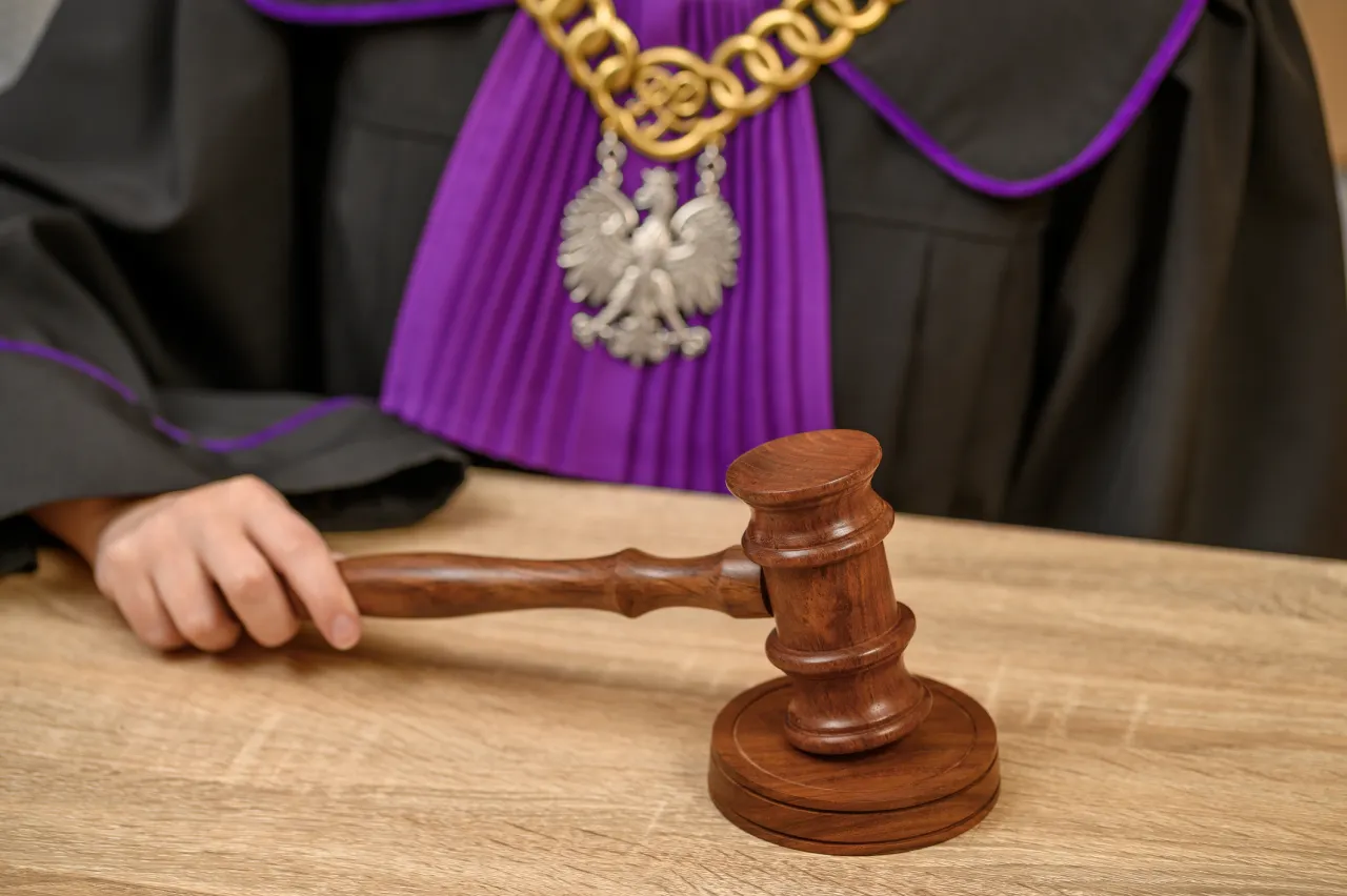 Sędzia w todze z orłem, młotek na stole. Czas oczekiwania na rozpatrzenie apelacji bywa długi.