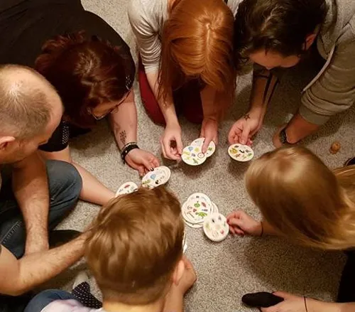 ludzie grający w szybkie gry planszowe na imprezie