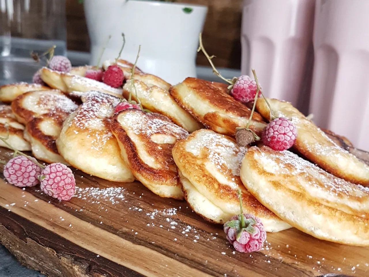 Pyszne placuszki z twarogu, posypane cukrem pudrem i ozdobione malinami. Idealne na śniadanie lub deser.
