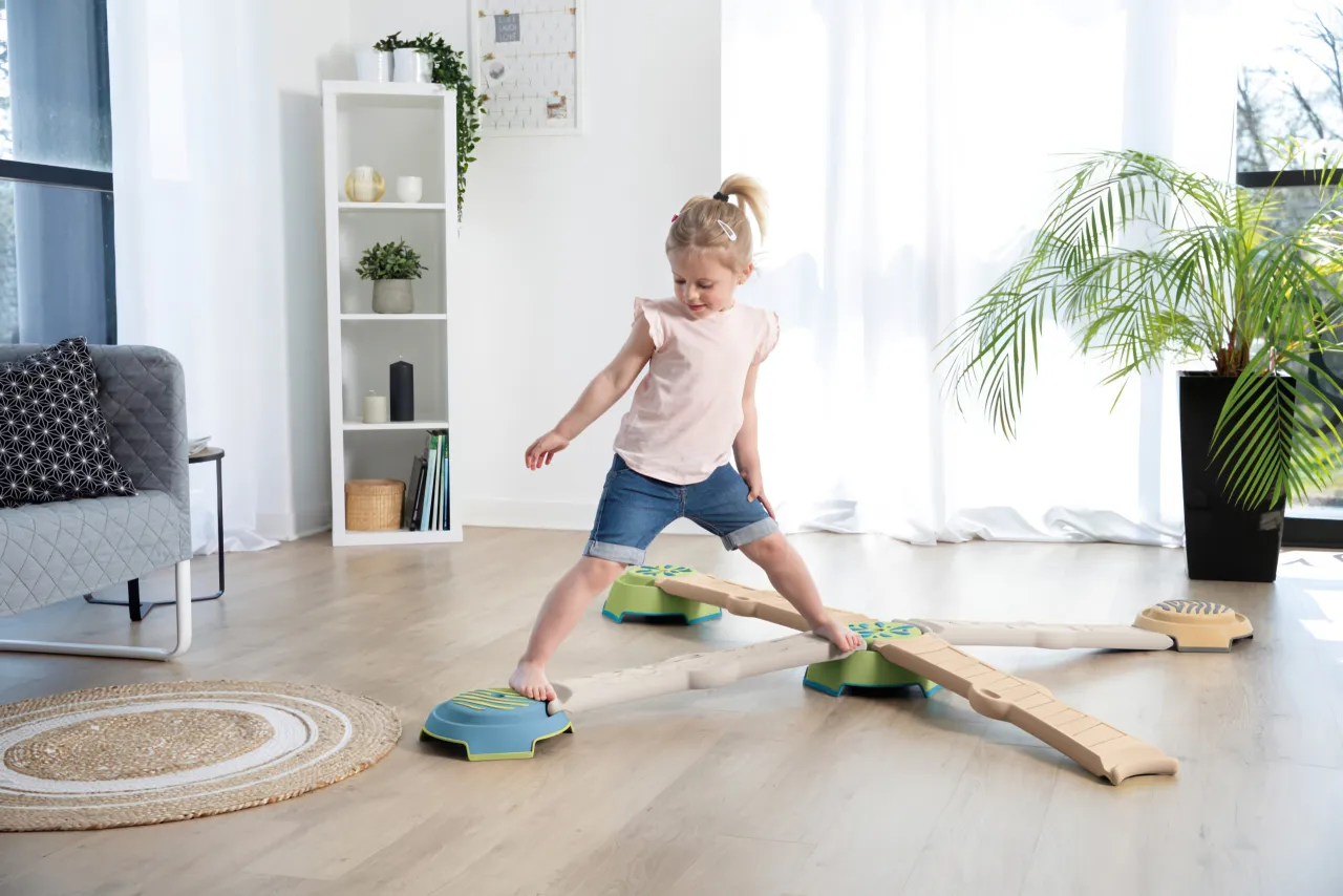 dzieci bawiące się i ćwiczące r&oacute;wnowagę w domu