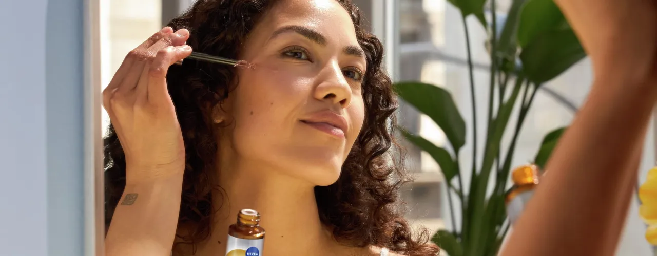 kobieta nakładająca serum na twarz