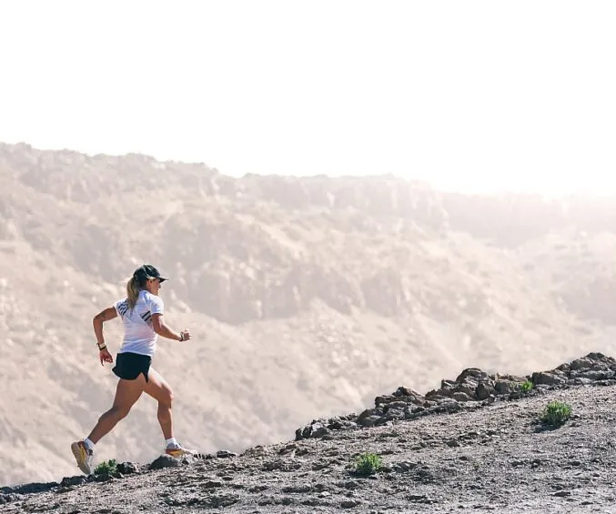 kobieta biegnąca pod górę, silne mięśnie ud, trening siłowy bieganie