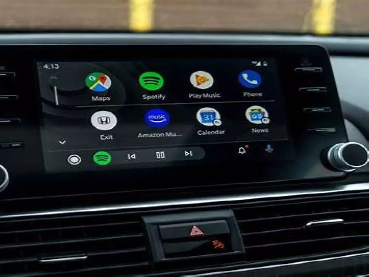 Ekran samochodu z ikonami aplikacji: Mapy, Spotify, Play Music, Telefon. Dowiedz się, jak włączyć android auto.