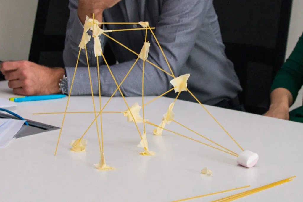 dzieci budujące wieżę z makaronu spaghetti i pianek