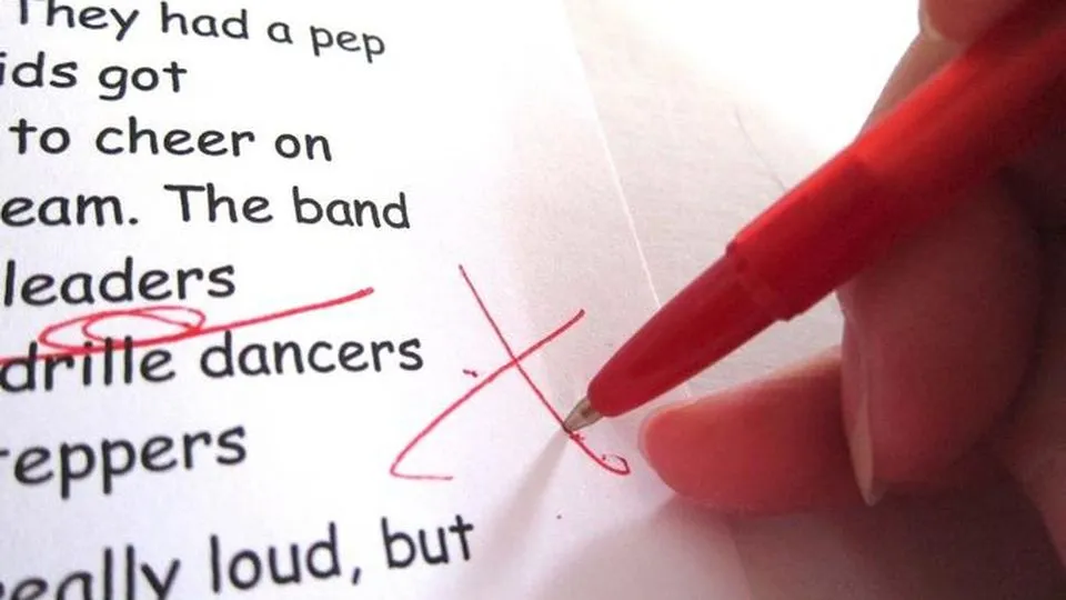 osoba sprawdzająca tekst z czerwonym długopisem