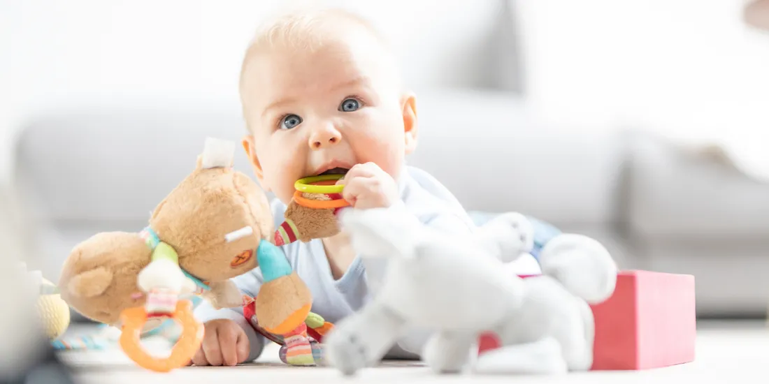 szczęśliwe niemowlę gaworzące bawi się zabawkami