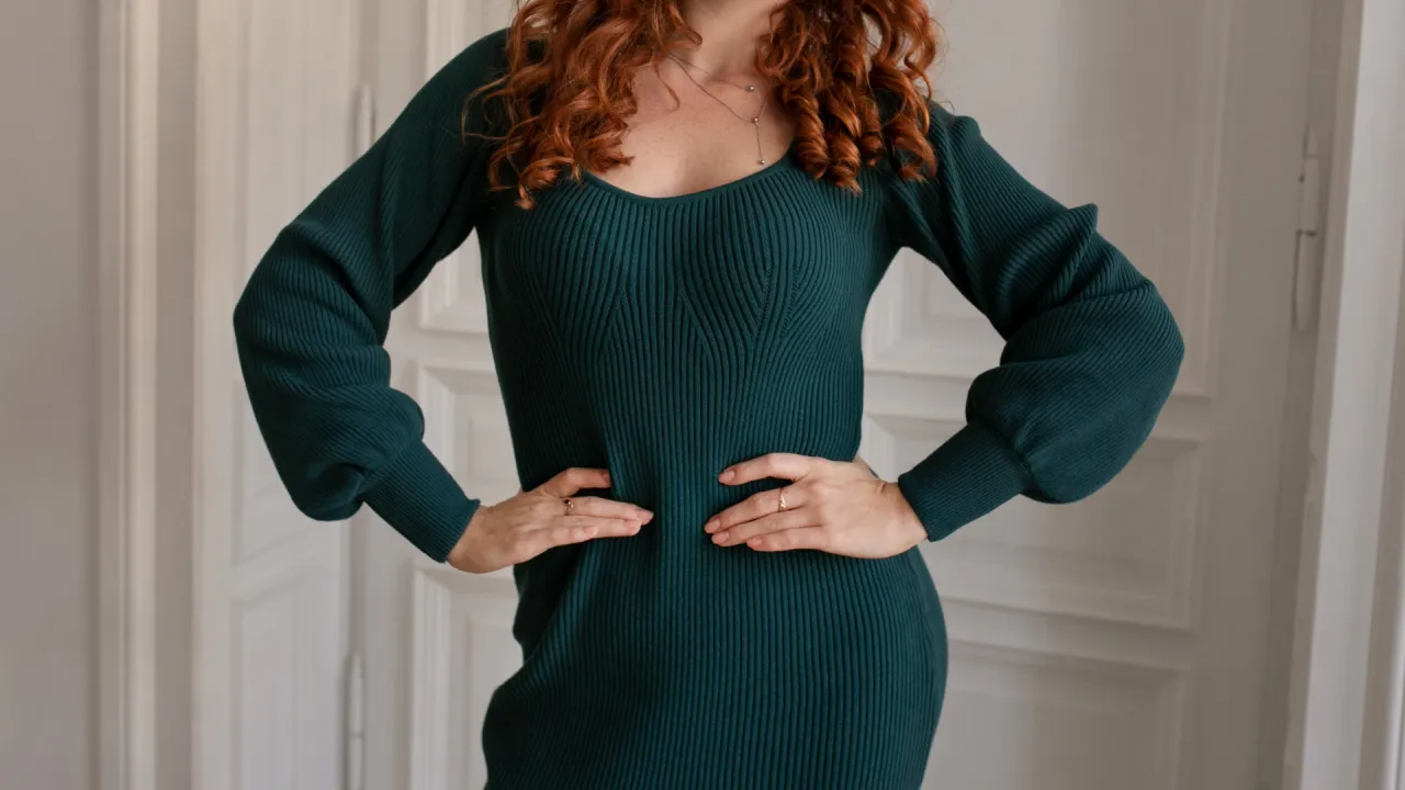 Kobieta w ciąży wybierająca ubrania w sklepie, uśmiechnięta