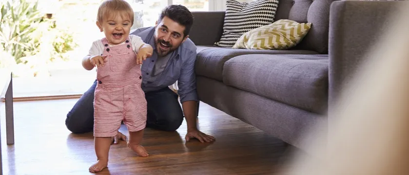 dziecko stawia pierwsze kroki przy kanapie