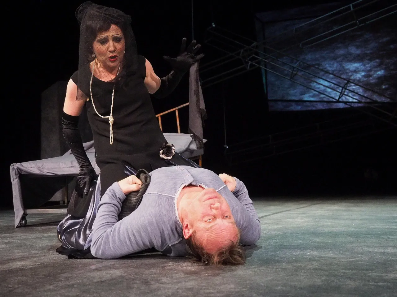 Aktorka w żałobnej kreacji klęczy nad leżącym mężczyzną. Czy to finałowa scena? Ile trwa spektakl w teatrze?