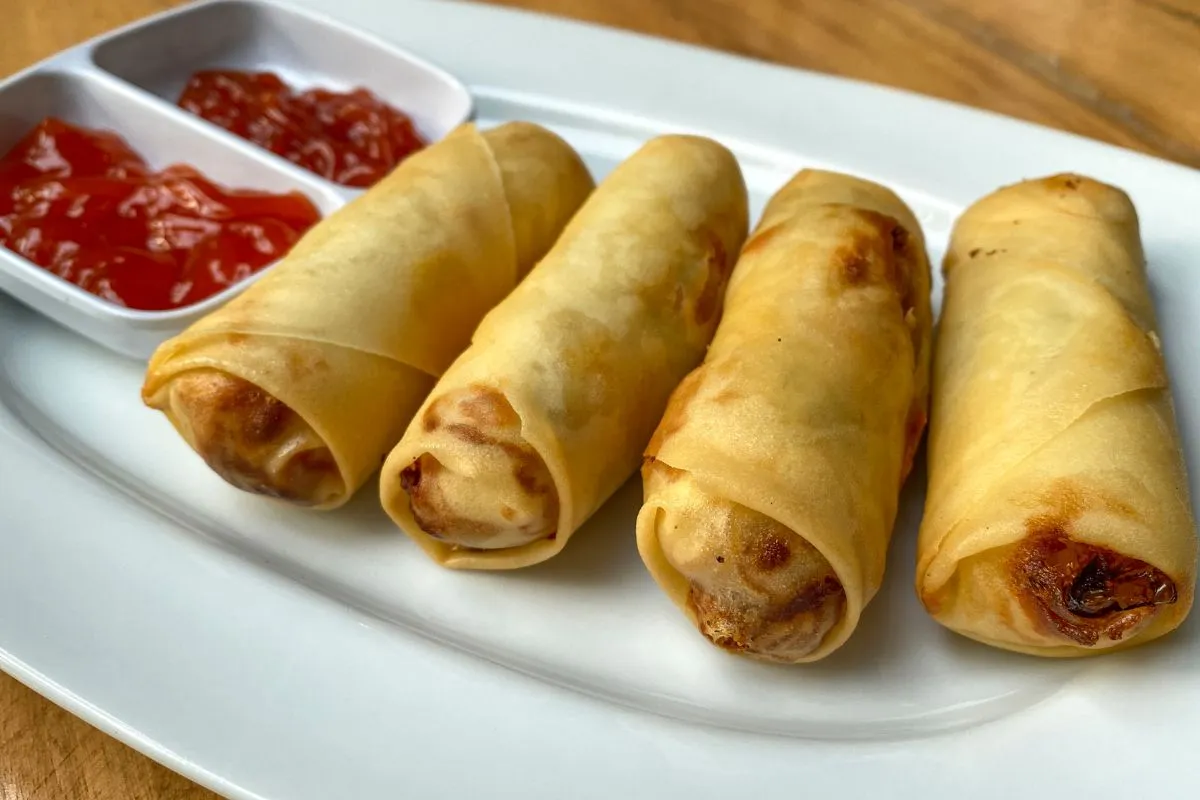 Chrupiące sajgonki, co to jest? Złociste rolki z farszem, podane z sosem. Idealna przekąska.