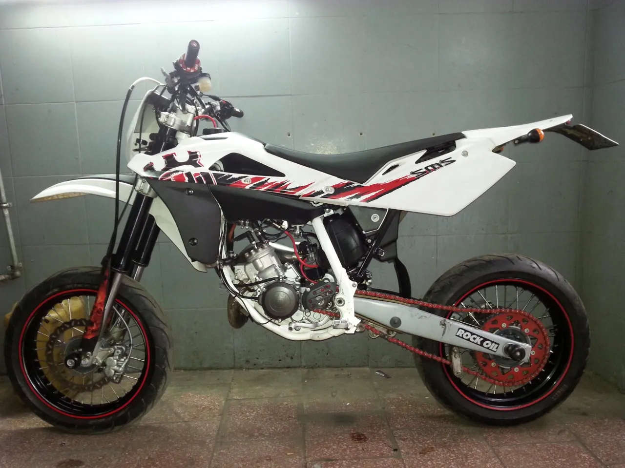 Husqvarna SM 125 z czerwonym łańcuchem i felgami. Poznaj husqvarna sm 125 dane techniczne i poczuj moc!