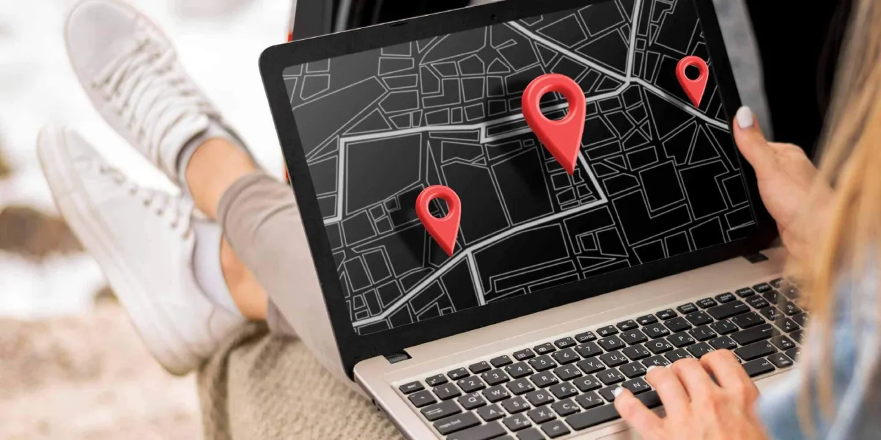 Kobieta pracuje na laptopie z mapą i pinezkami, optymalizując lokalne SEO dla swojej firmy.