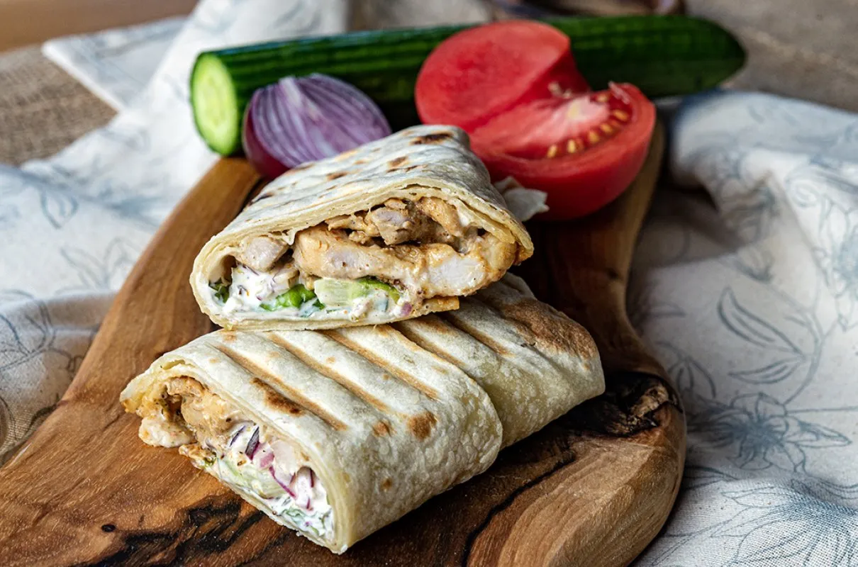 Pyszny kebab w tortilli z kurczakiem, warzywami i sosem. Idealny pomysł, jak zrobić kebab w tortilli w domu.